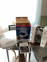 Both appliances with Oster box, styrofoam, manual visible