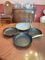 Four skillets displayed together showing interiors and handle styles