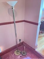 Both lamps standing in corner, showing relative sizes and finishes