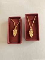 Pair of necklaces in boxes showing pendants and chains