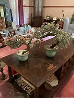 Both artificial bonsai trees on table showing overall size and pots