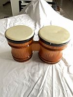 Top view of connected wood bongo drums with cream synthetic heads