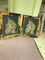 Pair of framed Thai embossed metal panels leaning together