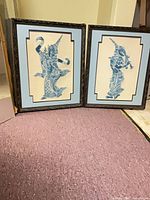 Both framed prints side by side on floor showing full fronts