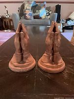 Front view of both terracotta praying hands sculptures