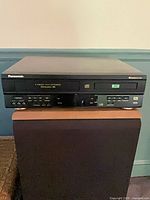 Front view showing Panasonic branding, VHS and DVD trays, control buttons