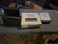 Overview showing Pioneer box, two black speaker units or faceplate panels, and Chrysler DVD player