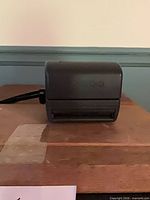 Camera closed showing rear and strap