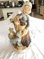 Front view of full figurine showing woman, dog and base