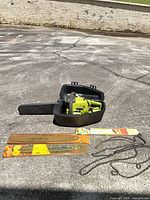 Poulan chainsaw in open case with replacement bars and chains on pavement