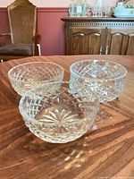 Three cut crystal bowls on wood table