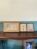 All three framed prints on shelf