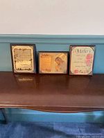 All three framed plaques on table