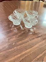 Three of the four clear glass teacups on tabletop showing side starburst pattern