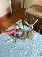 All five carved bird figurines displayed on table