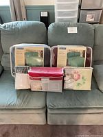 All five sheet sets on sofa, showing packaging and colors