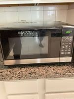 Front view showing Simply Perfect logo, black/stainless exterior, glass door