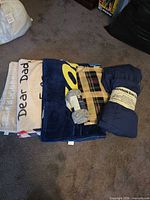 Rolled and folded blankets showing navy microsuede piece with plaid section
