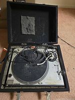 Turntable in foam case with cables and slipmat visible