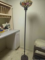 Full view of stained glass floor lamp beside workbench