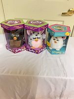 Three boxed Furby toys grouped together