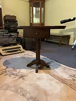 Full view of pedestal table with leaves down, drawer visible