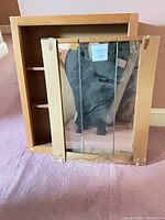 Cabinet box with interior shelves and detached tri-fold mirror doors