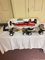 Overall lot showing boat in styrofoam, two RC buggies, Futaba transmitter