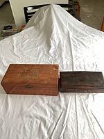 Both wooden boxes closed, side by side on table