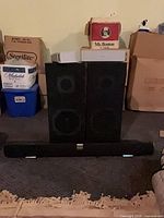 Front view of Vizio soundbar and two black floor speakers