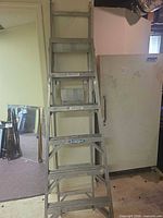 Full front view of Werner aluminum combination ladder leaning against wall