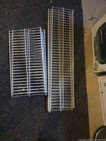 Two stacks of wire shelving panels showing different lengths