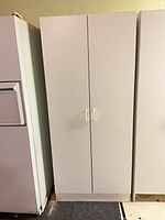 Front view of closed white two-door wardrobe