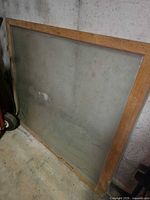 Front view of entire wood-framed glass sash leaning against wall