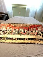 Full view of tapestry laid flat on table showing entire scene
