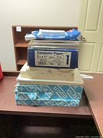 Stack of Xerox, computer paper box, HP multipurpose pack and other paper on desk