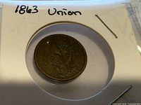 Token obverse in 2x2 flip showing Liberty design, date 1863 visible