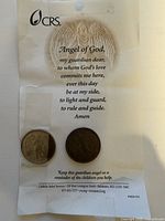 Two coins mounted on CRS prayer card showing prayer text