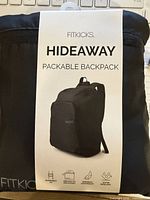 Front of packaged Fitkicks Hideaway packable backpack showing branding and feature icons