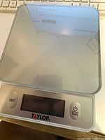 Top view of Taylor digital kitchen scale with glass platform, LCD display and control buttons