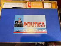 Box lid of Game of Politics with portion of score sheet and cards visible
