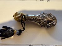 Full view of perfume dabber showing ornate sterling body, cap and tassel