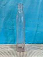 Full view of clear ribbed glass Shell bottle standing upright