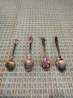 Four souvenir spoons laid out