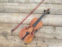 Full view of fiddle and bow on wooden surface