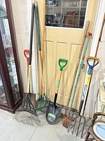 All eight garden tools leaning against door