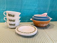 Group shot of stacked cups, plates and nested bowls displaying colours and patterns