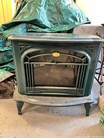 Front view showing entire green electric fireplace stove and overall condition