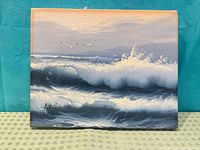 Front view of painting showing seascape scene, signature visible