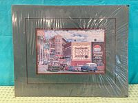 Front view of matted signed print shrink-wrapped